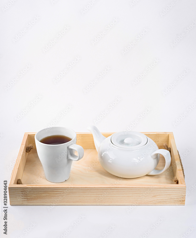 Teapot and cup on wood isolated on white Teapot and cup on wood isolated on white
