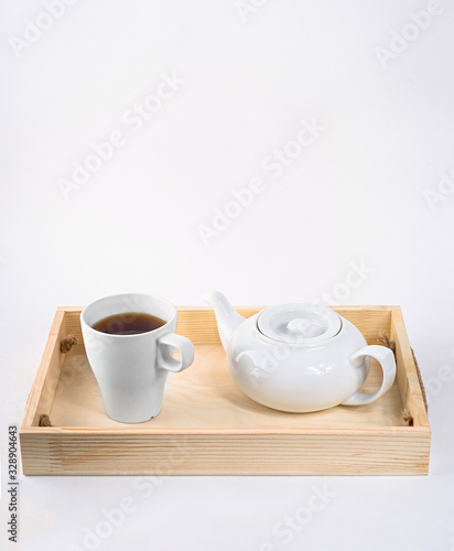 Teapot and cup on wood isolated on white