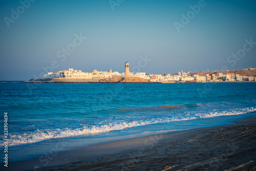 Beach with a lighthouse in the background at Sur's bay, Oman