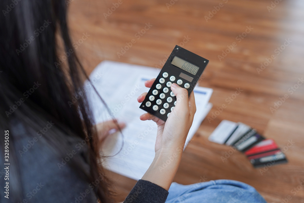Young asian woman using calculator to calculate the bill after meet financial problem and credit card debt with no money to pay back feel stressed and worried. Young asian woman using calculator to calculate the bill after meet financial problem and credit card debt with no money to pay back feel stressed and worried.