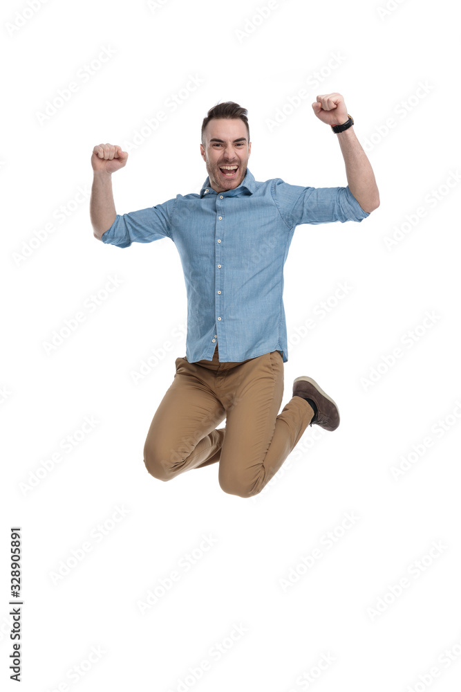 Cheerful casual man celebrating and shouting while jumping