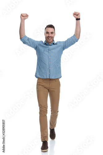 Cheerful casual man celebrating and laughing