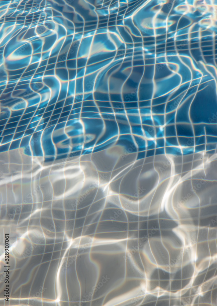 Sun reflection on the blue clear water ripples of swimming pool with mosaic bottom from above. Sun reflection on the blue clear water ripples of swimming pool with mosaic bottom from above.