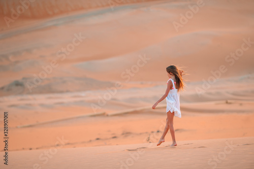Girl among dunes in desert in United Arab Emirates