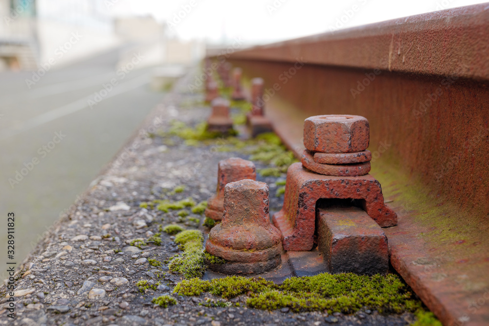 Close up and macro outdoor view at abandon and rusty bolt, screw and screw nut beside rust light rail steel beam covered in algae. Close up and macro outdoor view at abandon and rusty bolt, screw and screw nut beside rust light rail steel beam covered in algae.