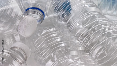 Plastic single use disposable bottles slowly panning close up across a pile ready for recycling