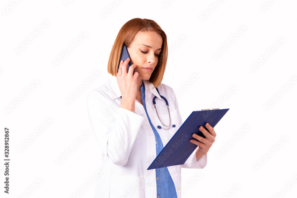 Mature female doctor having a call while standing at isolated white background Mature female doctor having a call while standing at isolated white background