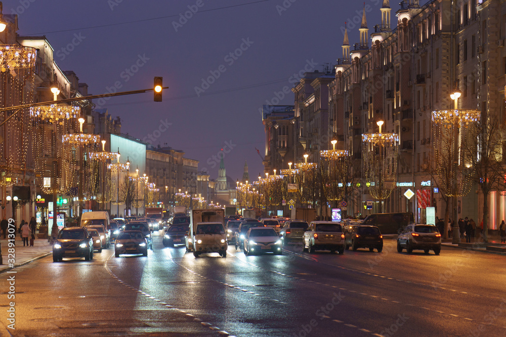 Moscow cityscape in night time. Moscow Kremlin tower in distance. City transportation theme. Frontal view.