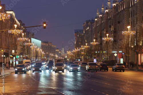 Moscow cityscape in night time. Moscow Kremlin tower in distance. City transportation theme. Frontal view.