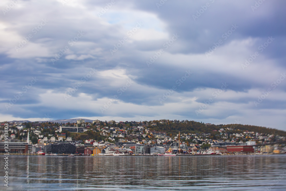 View of Tromso, with cathedral, Tromso Bridge, Tromsoya island, embankment and scenery beyond the city, Troms og Finnmark county, Norway, summer day