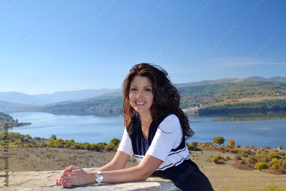 Beautiful Brunette Woman on a Lake Background 