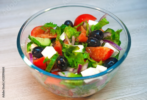 Greek salad with tomatoes, cucumbers and feta cheese with olives on the table