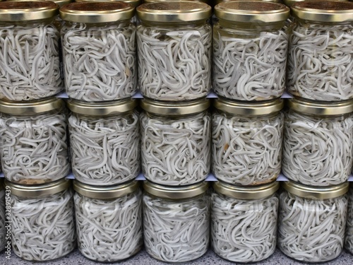 Foto Botes de gulas de pescado en conserva, alevines de anguilas.