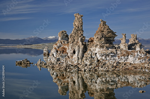 Winter landscape of Mono Lake with tufa formations, mirrored reflections in calm water, and Eastern Sierra Nevada Mountains, California, USA