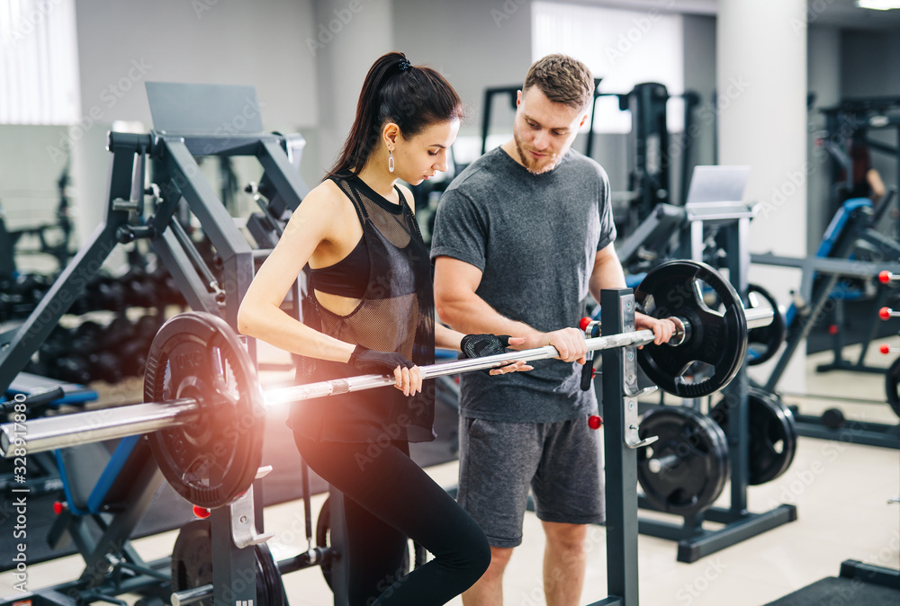 Trainer and client at the gym with sports equipment. Young and fit. nice body, athletic form. Healthy fitness life concept. Trainer and client at the gym with sports equipment. Young and fit. nice body, athletic form. Healthy fitness life concept.