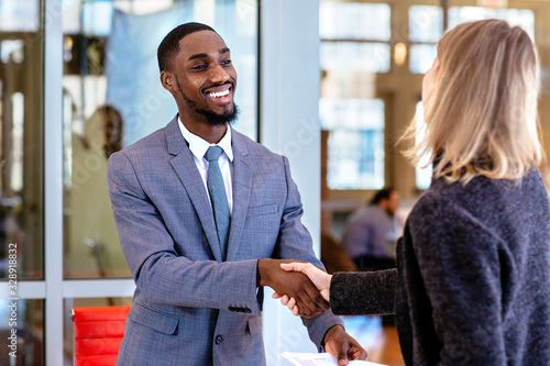 Принти на полотні Portrait of a smiling young man in business suit with female client or business