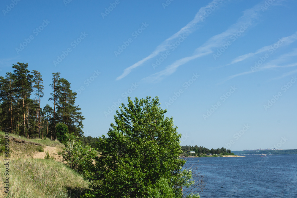 view of the shore of a picturesque river and traces of the plane in the sky view of the shore of a picturesque river and traces of the plane in the sky