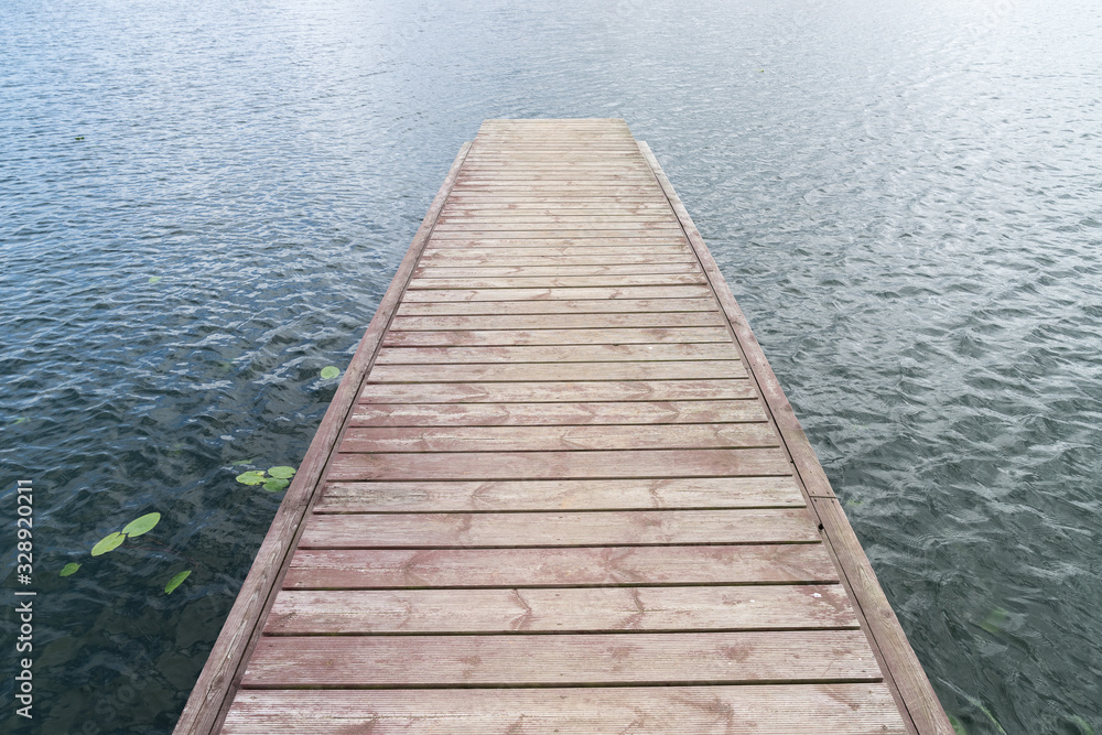 Wooden bridge for swimming on the shore of a lake. Blue water, summer nature landscape. Environmental concept, Latvia, Europe. Wooden bridge for swimming on the shore of a lake. Blue water, summer nature landscape. Environmental concept, Latvia, Europe.