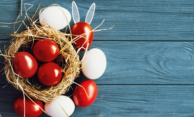 colored deep red Easter eggs in nest top view background, selective focus image. Happy Easter card