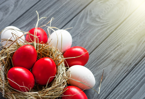 Canvas Print colored deep red Easter eggs in nest top view background, selective focus image