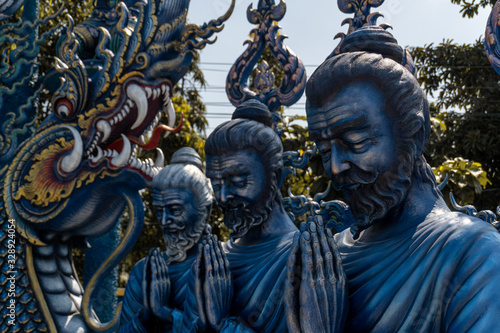 Chiang Rai's Blue Temple statues. Three typical thai statues located in a buddhist temple © Manuel