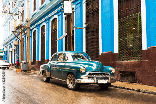 old blue green classic car in front of blue building in havana cuba © Michael Barkmann