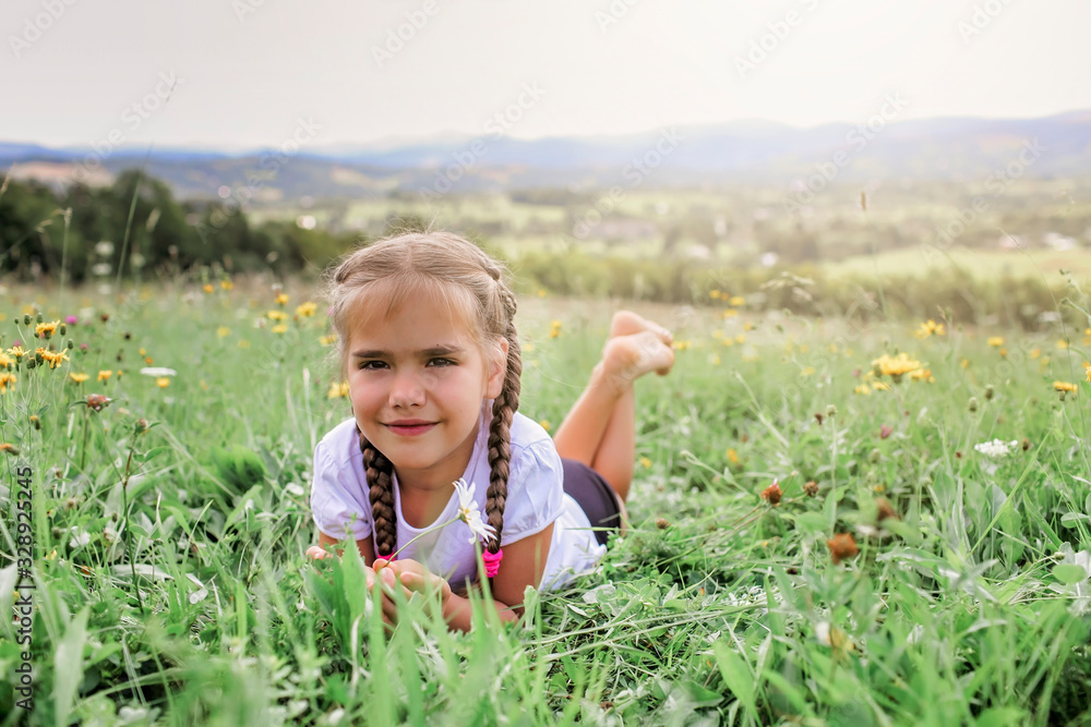 Attractive girl relaxing on the green grass on the top of the mountains in the morning Attractive girl relaxing on the green grass on the top of the mountains in the morning
