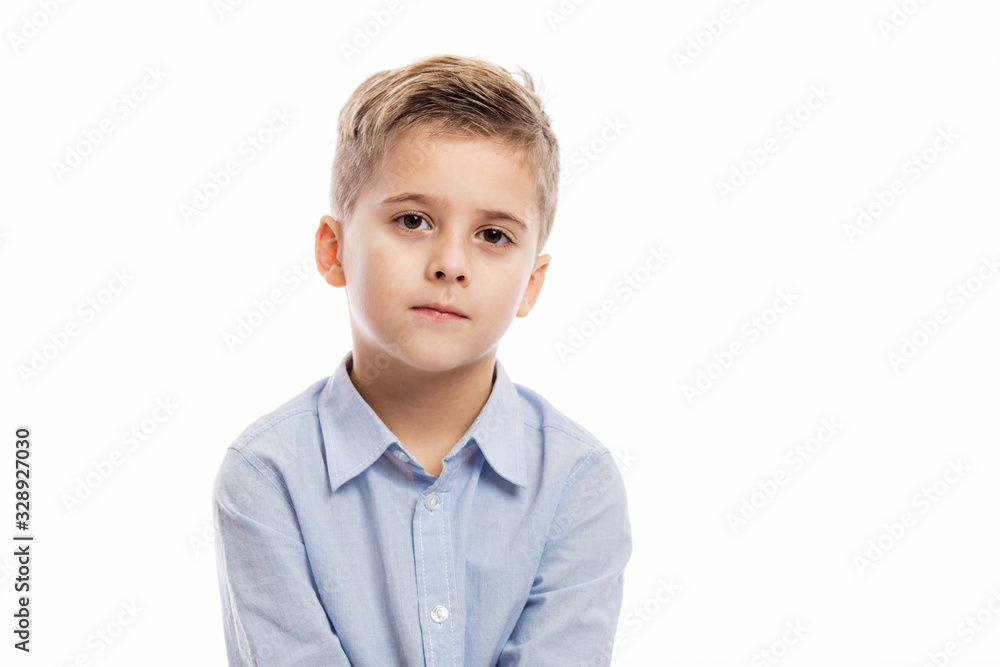 Serious school boy in a blue shirt. Isolated on a white background. Serious school boy in a blue shirt. Isolated on a white background.
