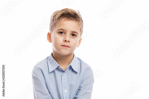 Serious school boy in a blue shirt. Isolated on a white background.
