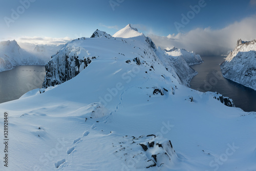 Panorama of snowy fjords and mountain range, Senja, Norway Amazing Norway nature seascape popular tourist attraction. Best famous travel locations. beautiful sunset within the amazing winter landscape