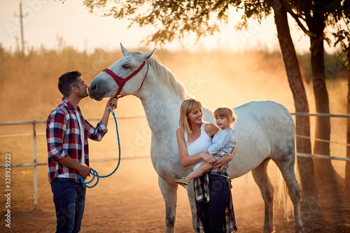 Family on a horse ranch. People have a fun with a horse.