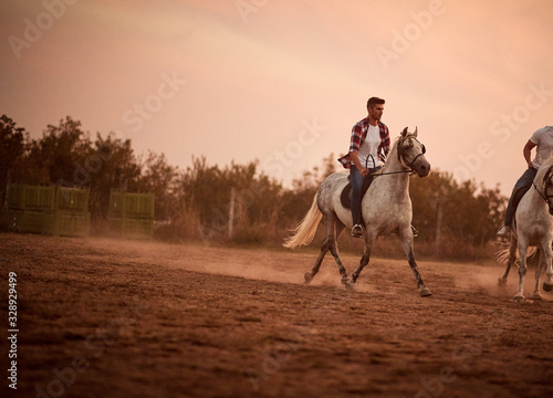 Man on galloping horse at sunset.