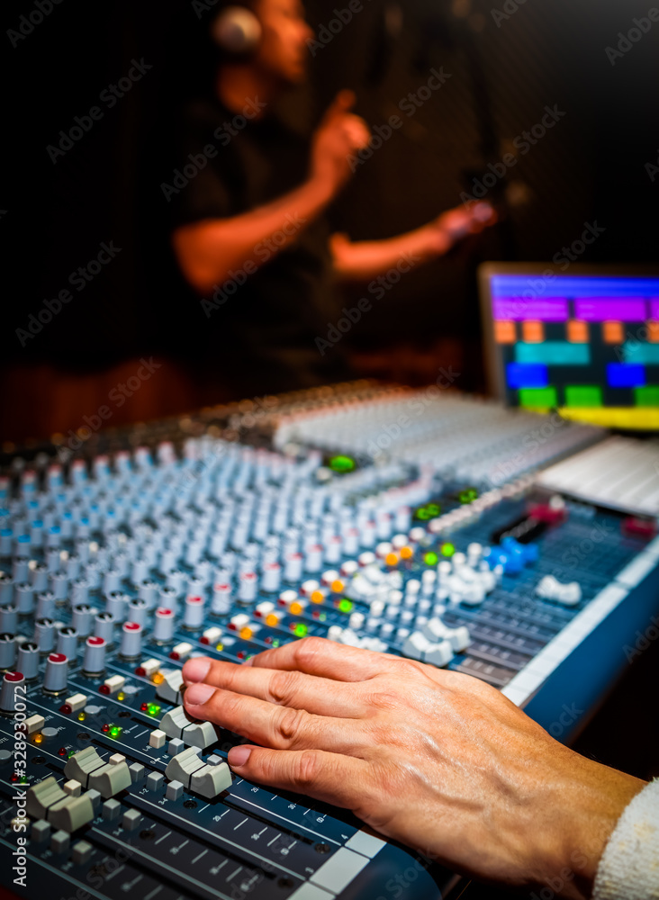 Fototapeta premium sound engineer recording singing voice on computer in recording studio