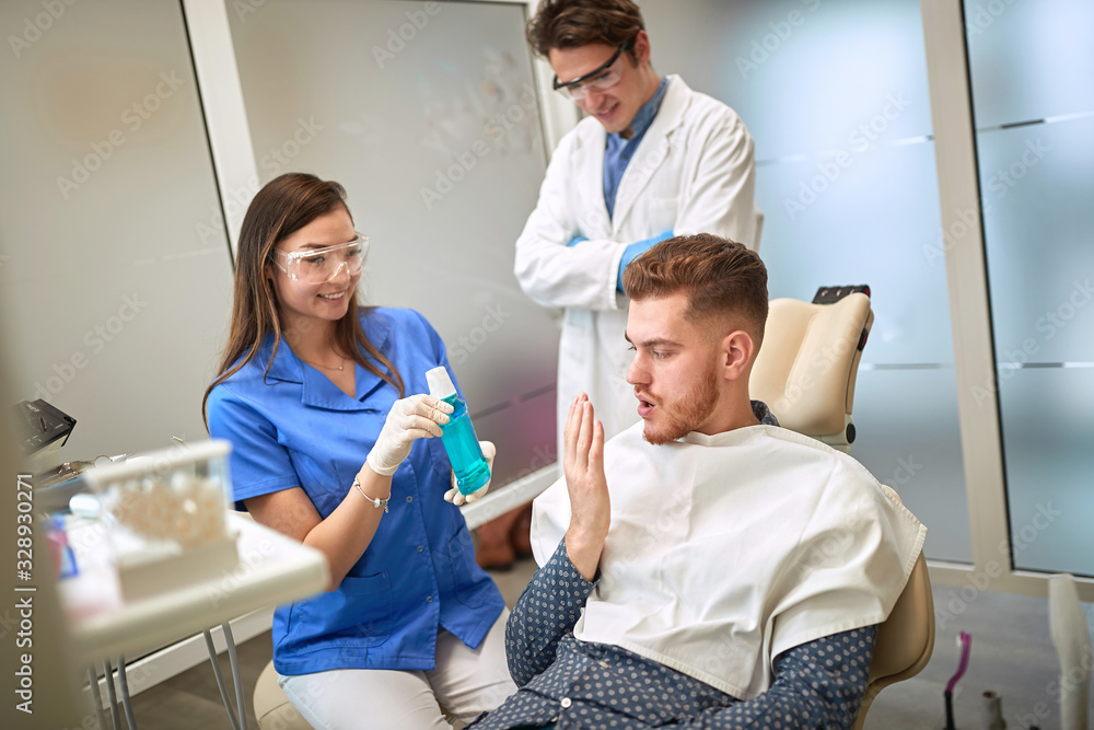 Dentist showing mouthwash to patient
