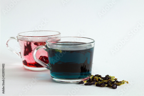 butterfly pea tea. glass cups of blue herbal and hibiscus tea on a white background. Healthy lifestyle. cup of hot blue and red tea with dry flowers on a white table. hot drinks. copy space.