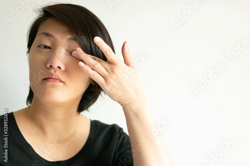 Wallpaper Mural An Asian woman uses a finger to wipe her eye on white background. Torontodigital.ca