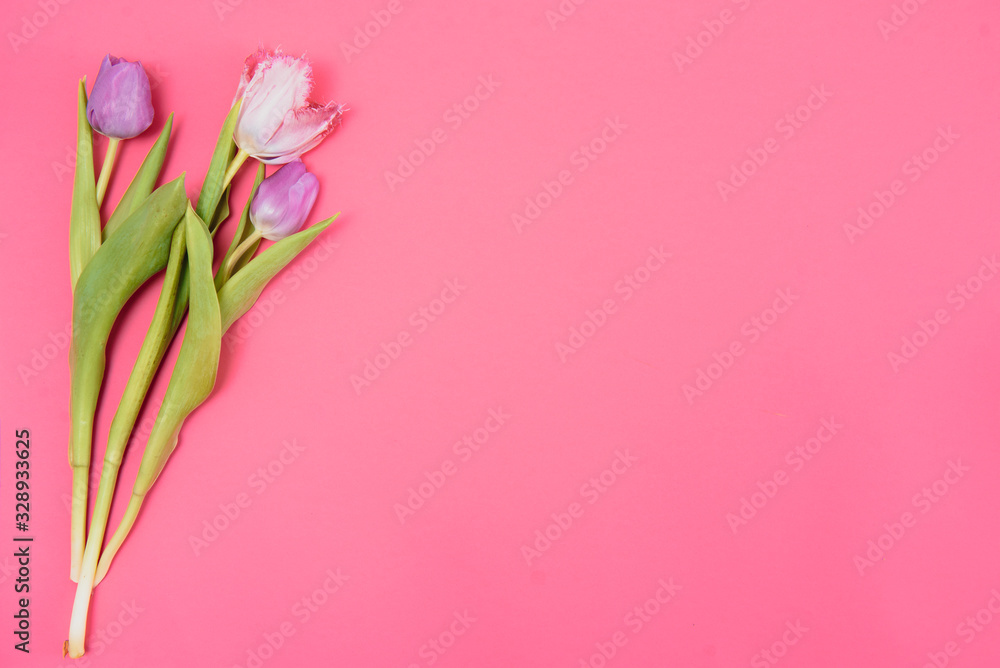 Naklejka premium Floral background with tulips flowers on pink pastel background. Flat lay, top view. Woman day background.