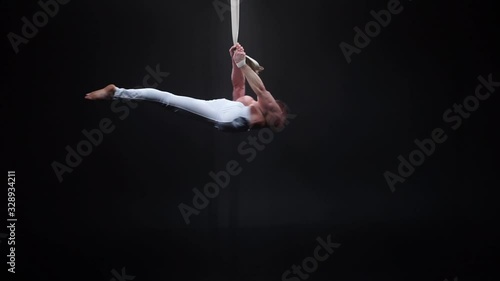 Muscular circus artist on the aerial straps. Concept of power, health and wellness  photo