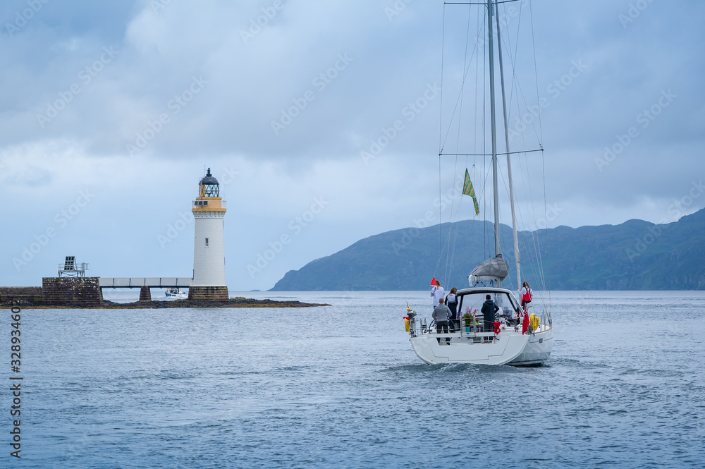 Sailing yacht passing Tobermory lighthouse. Popular cruising route at Inner Hebrides, Scotland. Sailing yacht passing Tobermory lighthouse. Popular cruising route at Inner Hebrides, Scotland.