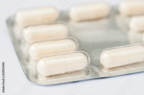 Closeup white antibiotics capsule pills in blister pack. Pharmacy background. Antimicrobial drug resistance. Pharmaceutical industry. Global healthcare.