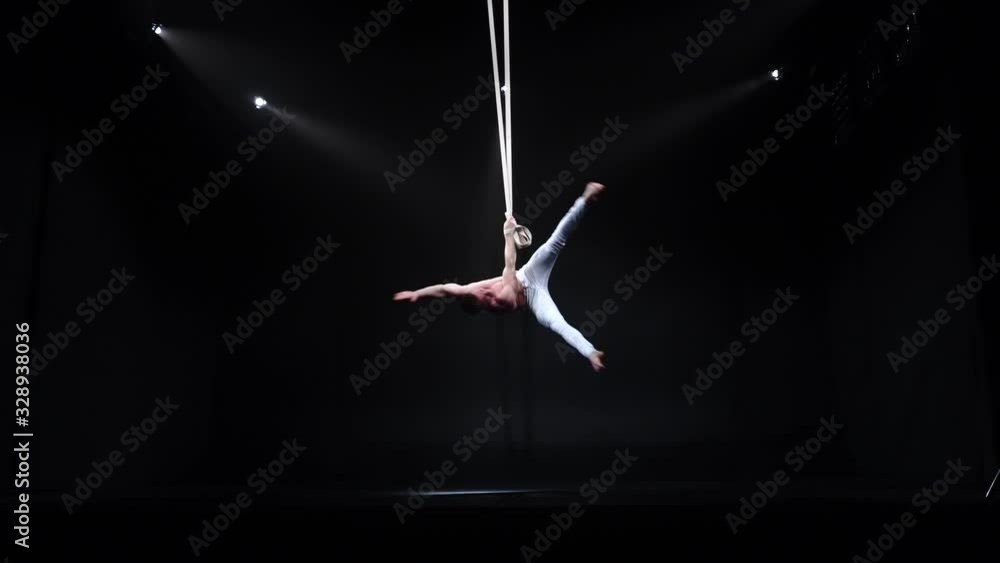 4k Muscular circus aerialist on the aerial straps in black studio 4k Muscular circus aerialist on the aerial straps in black studio