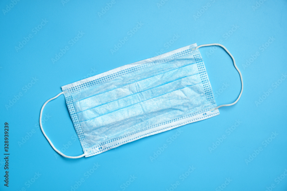 Protective methecin mask on the face on a blue background. Protective methecin mask on the face on a blue background.
