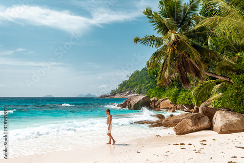 Seychelles tropical Island, Young man on the white beach during Holiday vacation Mahe Seychelles, Praslin Seychelles photo