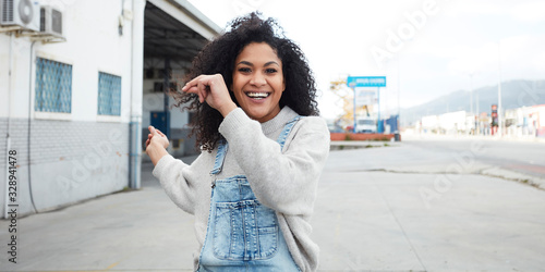  pretty young black woman with afro hair laughing and enjoying
