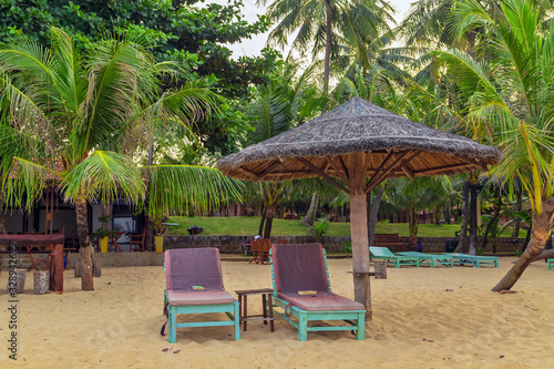 Long Beach  Phu Quoc Island  Vietnam. Nobody on the beach. Palm tree bamboo umbrellas and sun chairs in background.