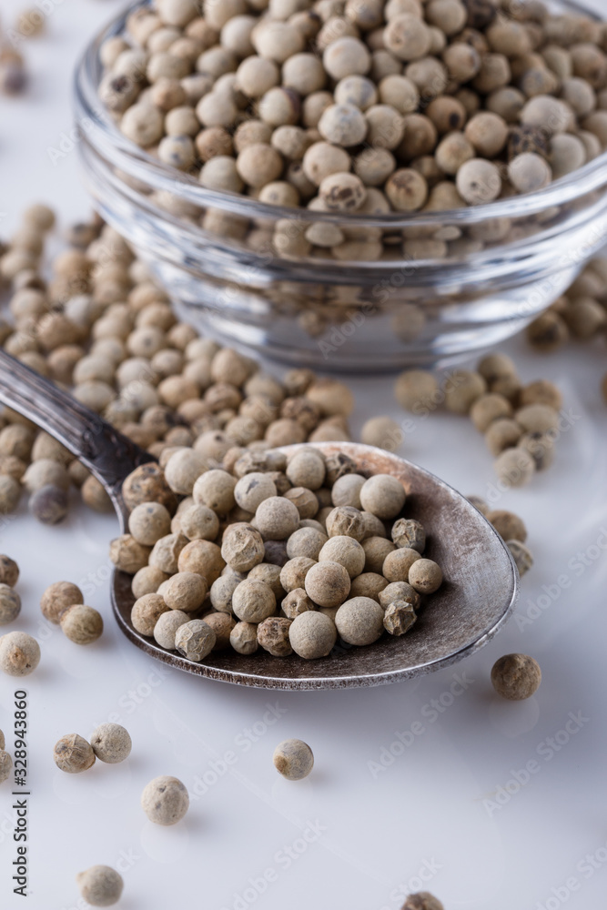 white peppercorns in glass bowl with spoon white peppercorns in glass bowl with spoon