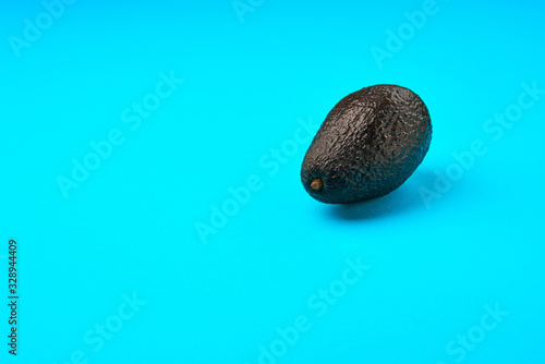 A fresh avocado on blue background.