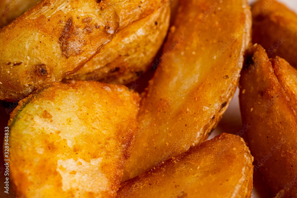 Rustic fried potato in close-up on a paper background. Rustic fried potato in close-up on a paper background.