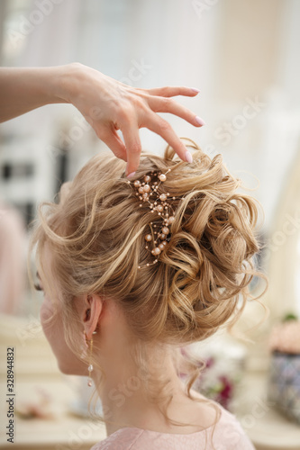 Fotografia Makeup artist, hair professional stylist makes young beautiful bride bridal make