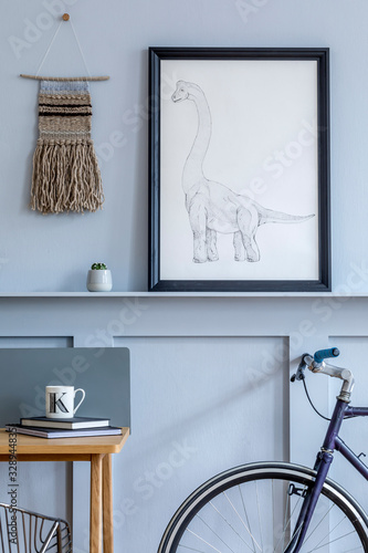 Stylish scandinavian living room with mokc up poster frame on the shelf, wooden desk, bicycle, office supplies and personal accessories in design home decor. photo